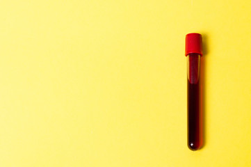 Test tube with blood isolate on a yellow background