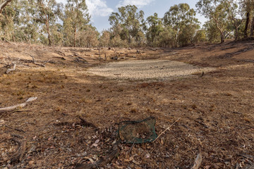 A dried dam in a waterless and dry landscape