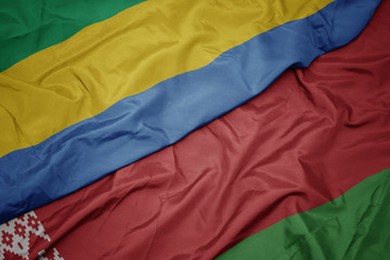 waving colorful flag of belarus and national flag of gabon.