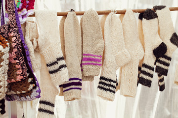 a row of wool knitted white socks . handmade work. the concept of zero waste. rustic style