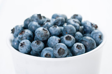 bilberry fruits at white ceramic cup