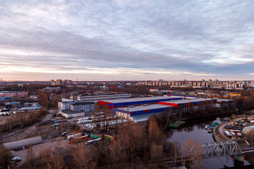 Aerial photography of the evening Industrial district of a large Russian city with warehouses, warehouses, offices and buildings. Beautiful sky at sunset.