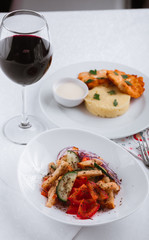 
dinner menu, feast and chicken cutlet with salad and red wine in combination with a tablecloth, tableware on the table