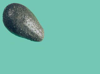 Avocado for the keto diet. Fresh avocado isolated on blue background closeup. Ripe fresh green avocado. Art green avocado.