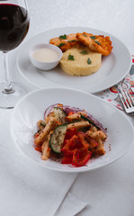 
dinner menu, feast and chicken cutlet with salad and red wine in combination with a tablecloth, tableware on the table