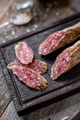 Beef jarky sausage with spices on wooden board with garlic pepper jar wooden