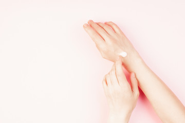 Woman moisturizing her hand with cosmetic cream, concept for feminine blog, social media, beauty concept