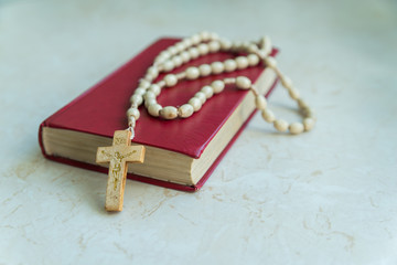
rosary and holy bible on the table