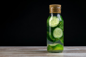 Detox water with cucumber, lime and mint in bottles