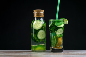 Citrus fruit and herbs in glass on wooden board, dark background