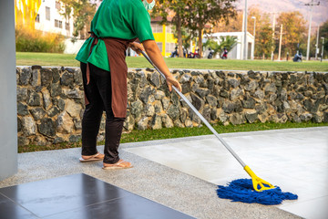 Female Janitor Cleaning Floor With Mopping  on modern building