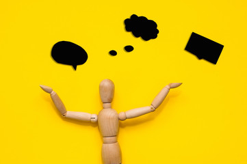 Wooden figurine holding blank placard against color background