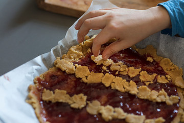 child preparing a very goog jam tart