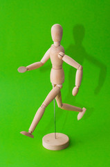 Wooden figurine holding blank placard against color background