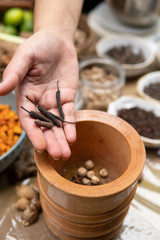 grinding cardamom, clove and traditional spice ingredient for jamu herbal drink