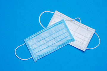 Blue and white medical surgical mask for protection against the virus on a colored background