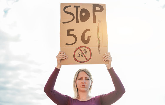 Young woman protest against 5g and cell towers - Electromagnetic danger pollution, activist and internet of things concept - Focus on banner