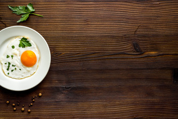 Fried eggs on plate on wooden table top view copy space