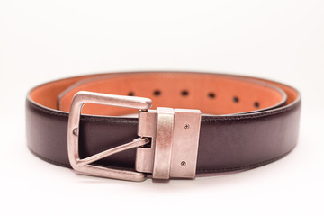 Close-up classic men's brown leather belt on a white background. 