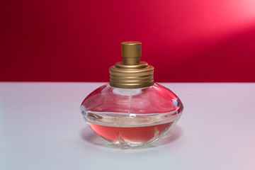 Perfume bottle isolated on red background