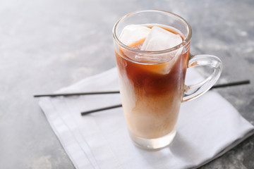 Glass cup of tasty iced coffee on grunge background