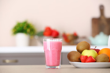 Glass of healthy smoothie and ingredients on kitchen table