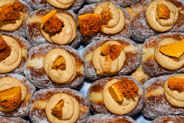 Many donuts placed in a tray, for sale at food market.