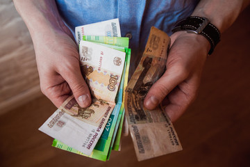 Hands holding russian rouble bills and small money pouch. Toned picture