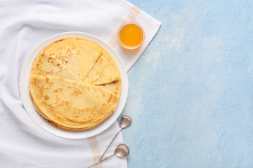 Tasty blini with honey on color background