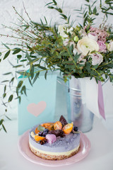 Raw vegan cake with fruits, seeds, chocolate and flower decoration