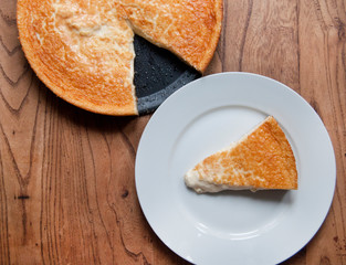 Homemade cheesecake on white plate and wooden table