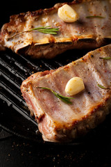 Grilled pork ribs with rosemary, spices and garlic in a frying pan grill