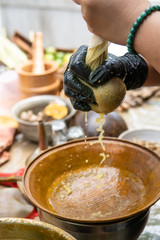 close up of hand filtering some ingredient for jamu drink