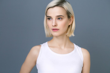 Obraz premium Beautiful woman blonde short hair natural casual make up over gray wall