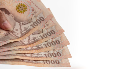 Hand holding Thai banknotes 
5 thousand baht On isolated white background. 