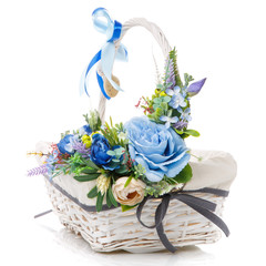 Floral easter decor in blue on a white wicker basket on white background