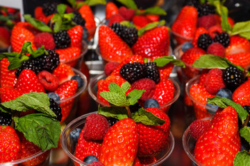 Freshly picked strawberries in plastic glass for sale in Italy