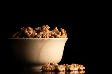 Walnut dry fruits in a brown bowl against dark background