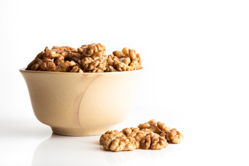 Walnut dry fruits in a brown bowl against a white background