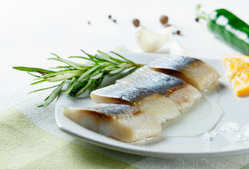 fillet herring serving with vegetables on white plate