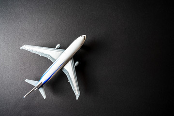 Toy collectible passenger airplane isolated on black background with own space for text.