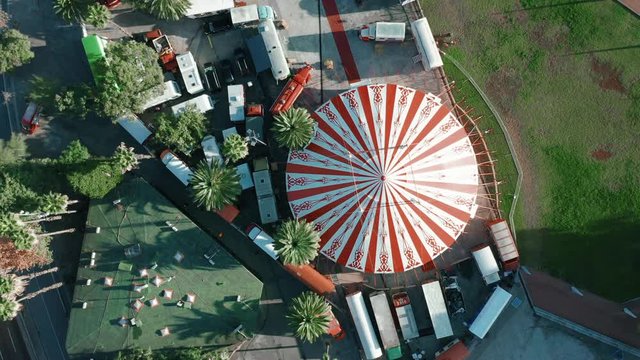 Aerial, drone view of bright round dome of street circus chapiteau. warm morning light on the roof of travelling circus. attractions for tourists and locals. used for theater and entertainment events