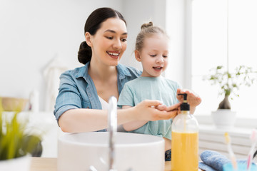 girl and her mother are washing hands