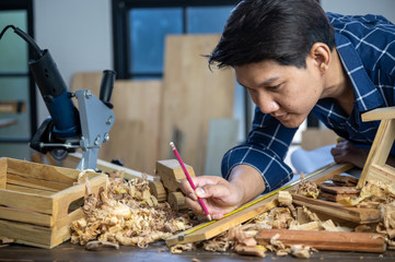 A carpenter is making crafts from wood.