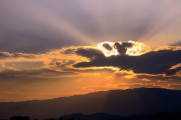 Sun beams or rays breaking through the dark clouds at sunset.  Beautiful spectacular conceptual meditation background.