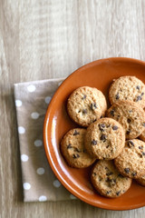 Chocolate chip cookies and polka dot napkin on wooden table. Top view.