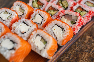 Sushi rolls of japanese food in restaurant. Sushi rolls set with salmon, vegetables and caviar closeup. Japanese restaurant menu