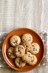 Chocolate chip cookies and polka dot napkin on wooden table. Top view.