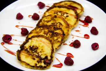 Ukrainian cottage cheese fritters, syrniki with jam on white plate. Cheese pancakes with raspberry without GMO. Delicious breakfast food at the morning.