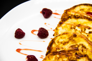Ukrainian cottage cheese fritters, syrniki with jam on white plate. Cheese pancakes with raspberry without GMO. Delicious breakfast food at the morning.